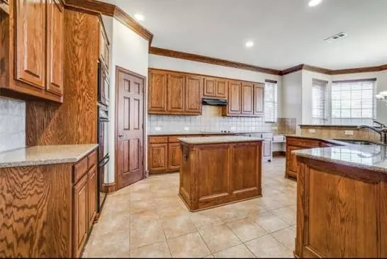 Large island kitchen with dark oak cabinets and trim before respraying