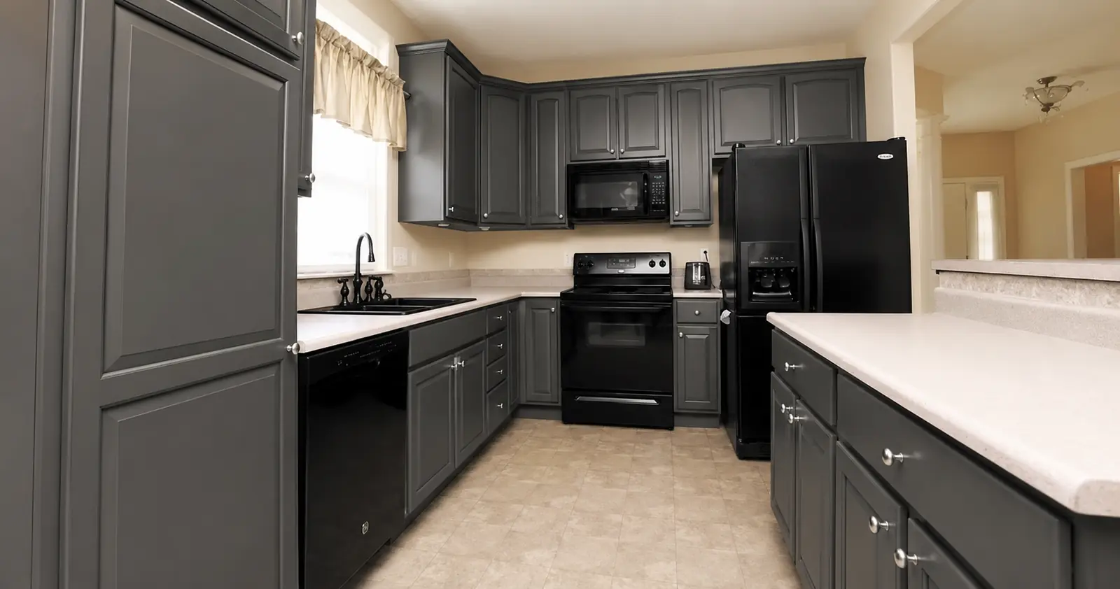 The same galley kitchen with cabinets resprayed in graphite grey